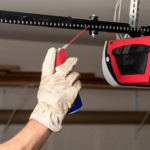 A photo of a hand doing routine maintenance on a garage door